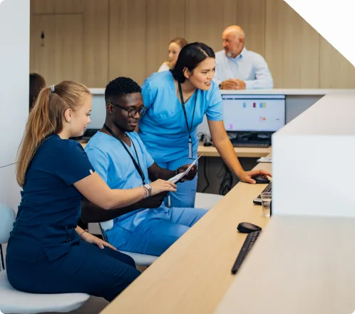 A clinical support team reviewing a patient interaction together at a workstation
