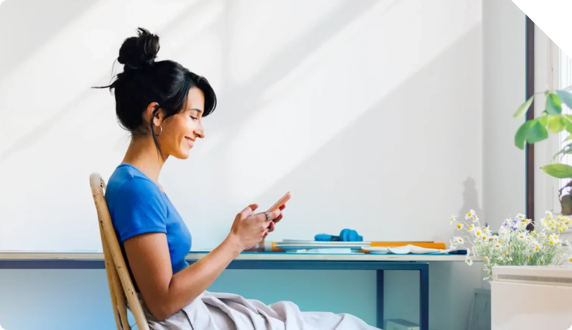 A healthcare contact-center agent relaxing at her desk while reviewing a call on her phone