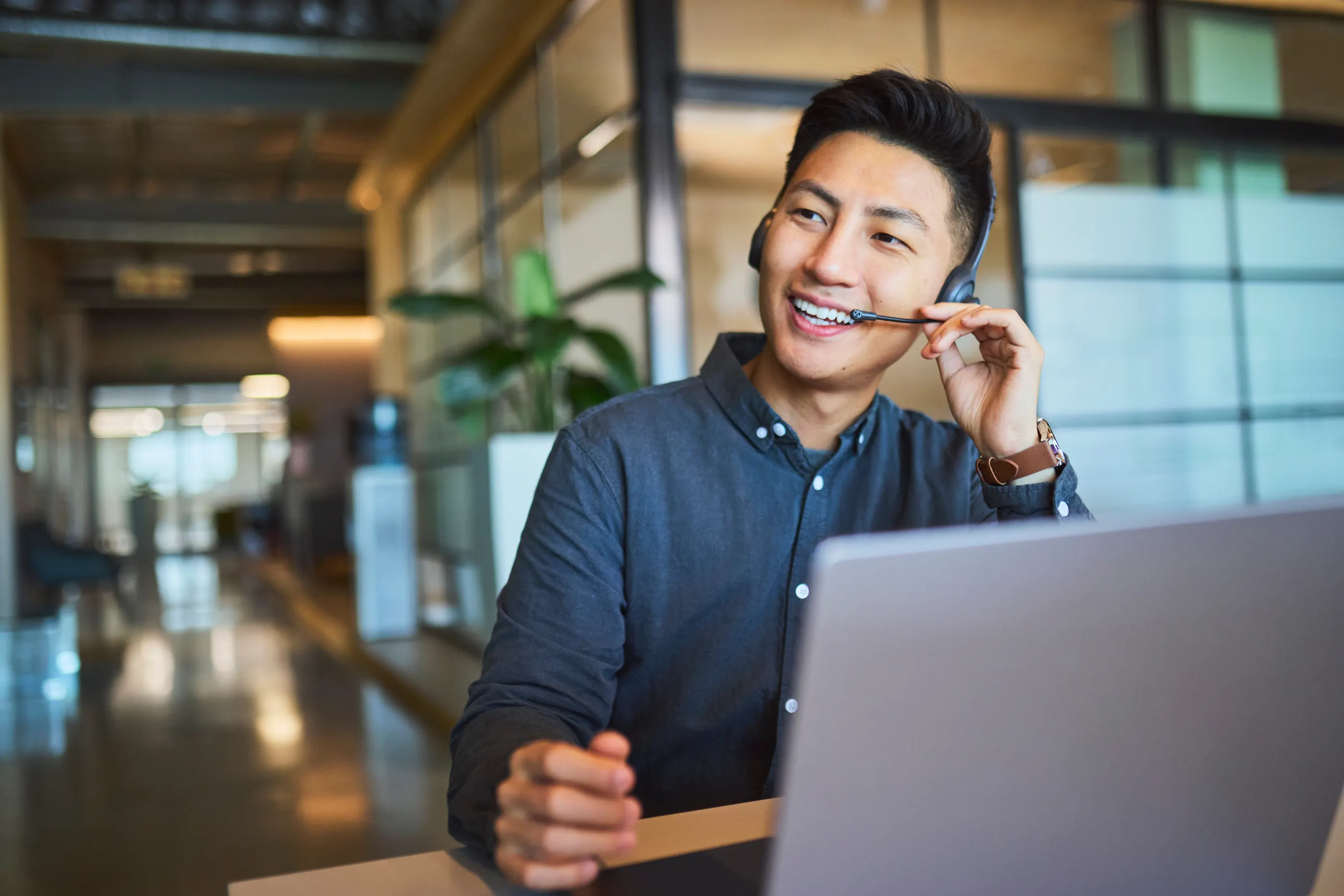 A member support agent smiling while taking a call on a headset