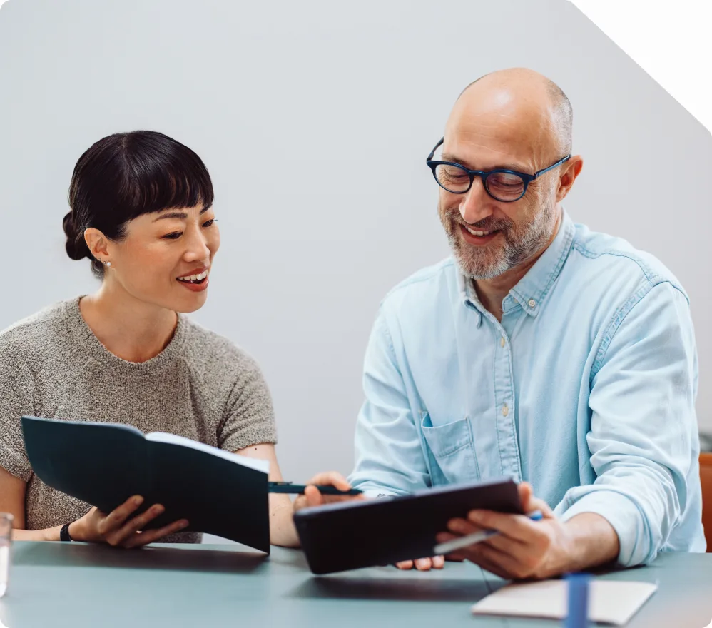 Two care coordinators reviewing provider information together at a desk
