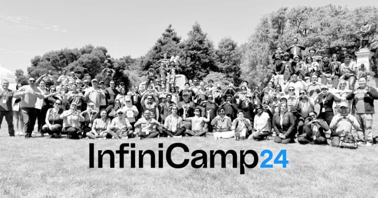 A black-and-white photograph of the Infinitus team in San Francisco, with "InfiniCamp24" appearing overtop of it in black and blue text.